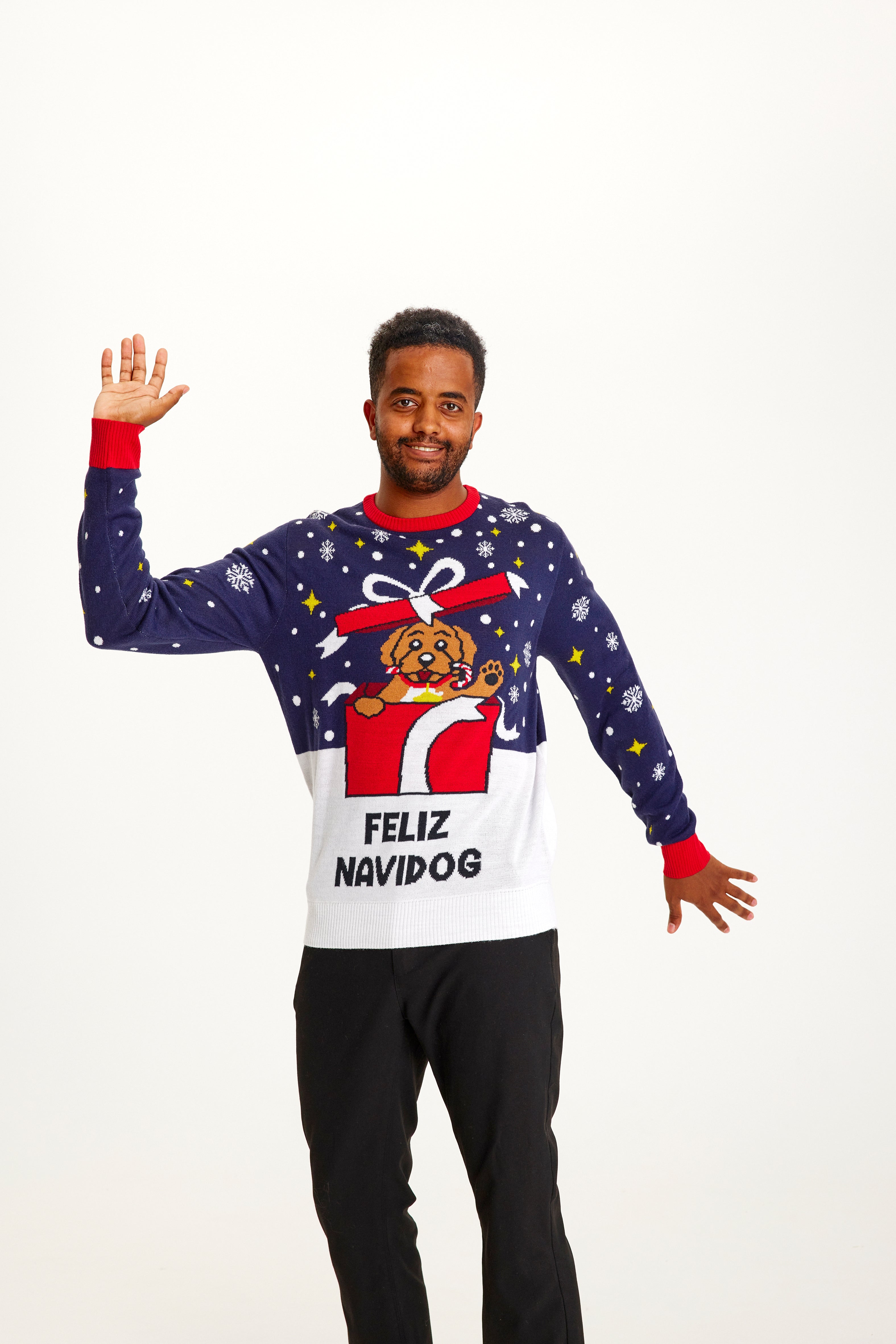 Un uomo sorridente che indossa un maglione natalizio blu.